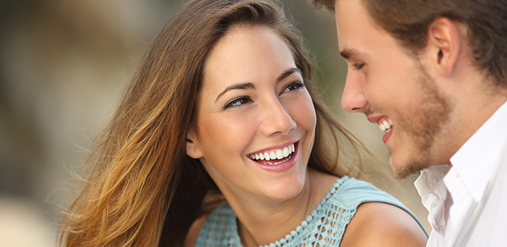 a young couple laughing and looking at each other they both have great smiles