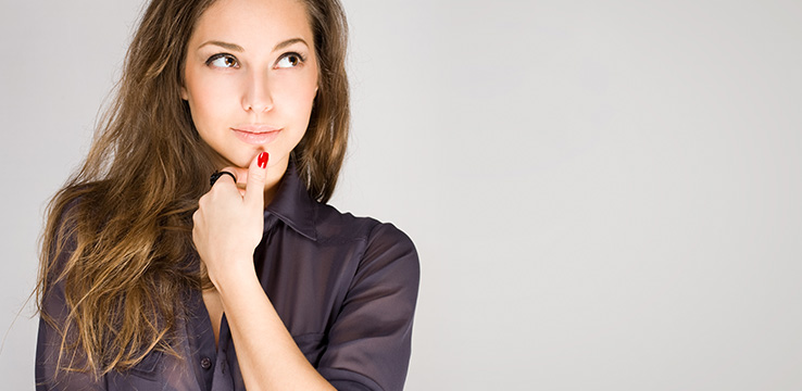 pretty young lady with her thumb to her chin and eyes looking up as if she is thinking